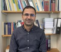Man sitting in front of bookshelf